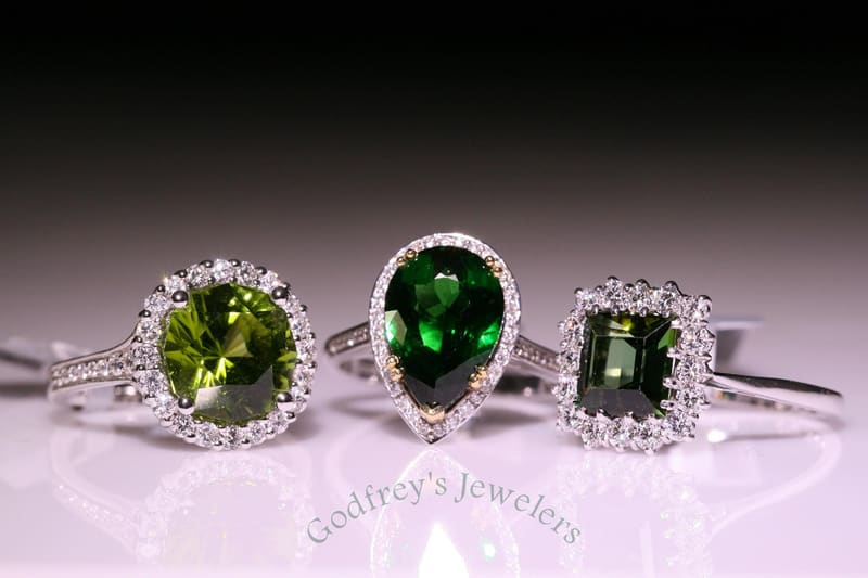 Green gemstone rings in diamond halos
